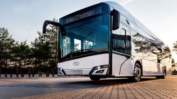 Front three-quarter view of a Solaris Urbino 12 hydrogen bus on paving at dusk with a Hydrogen licence plate
